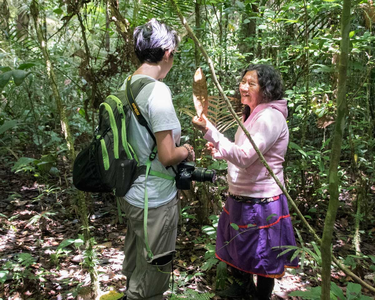 A local Siona guide explaining a medicinal plant to a visitor | Cuyabeno, Ecuador | ©Angela Drake A local Siona guide explaining a medicinal plant to a visitor | Cuyabeno, Ecuador | ©Angela Drake